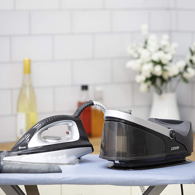 Swan SI11010BLKN Steam Generator Iron siting on ironing board-min